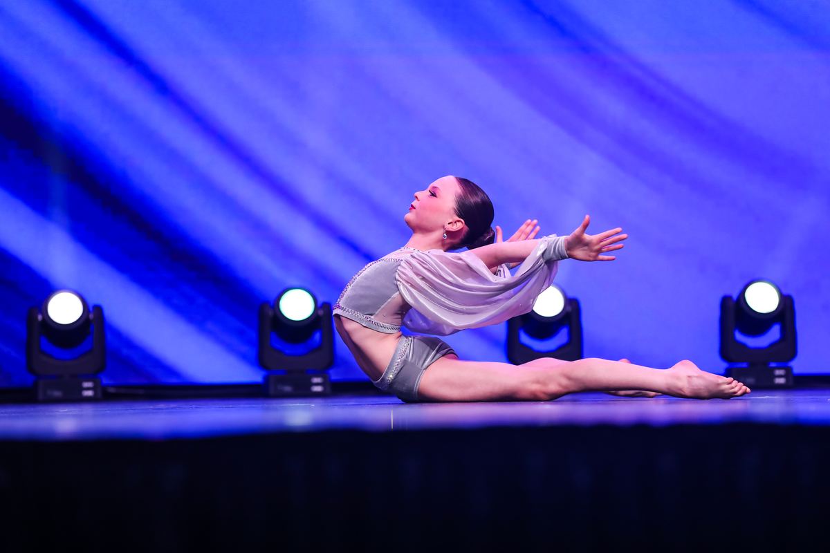 A soloist arching back on a blue-lit stage